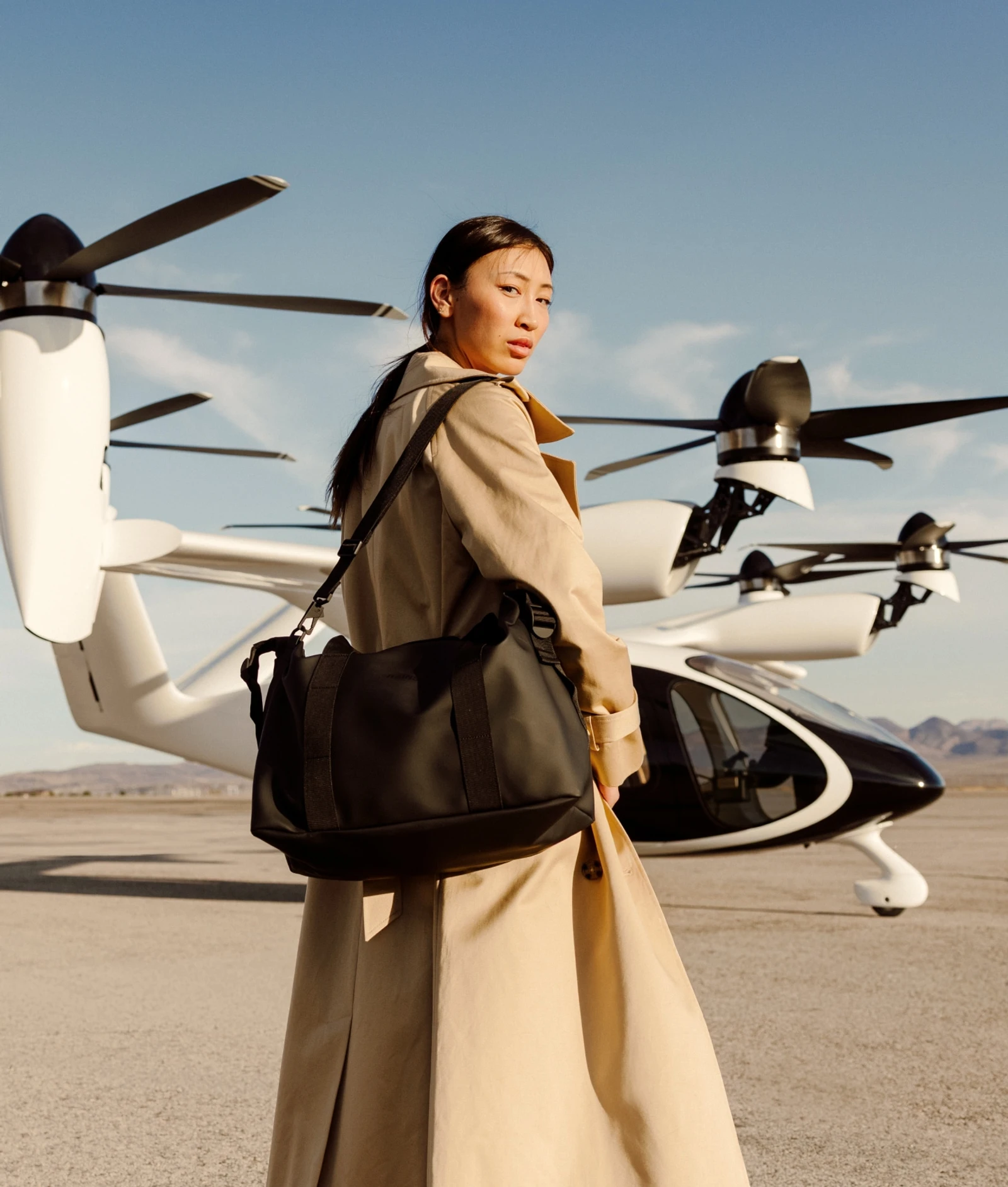 Professional woman boarding Joby aircraft carrying luggage